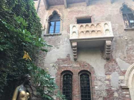 Дом, балкон и статуя джульетты в вероне. фото