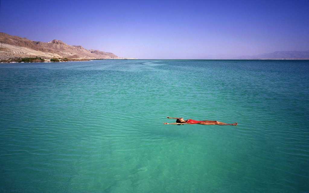 Вода становится розово-красной возле мертвого моря в иордании