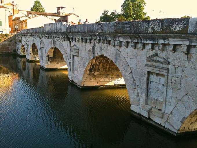 Мост Тиберия – визитная карточка города Римини. Возраст этой достопримечательности составляет 2000 лет. Мост поражает своей прочностью – в наши дни по нему не только прогуливаются горожане и туристы, но и ездят все виды транспорта. Мост Тиберия стоит на р